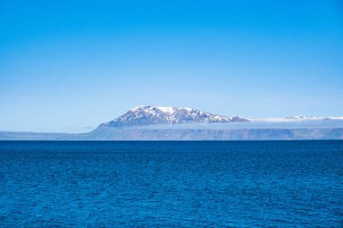 İnanılmaz deniz manzarası, Atlantik okyanusu ve Kuzey İzlanda 'da karla kaplı dağlar.