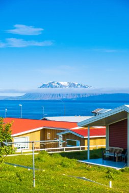  Bakkafjrur kasabası, İzlanda, arka planda kar altında okyanus ve dağ 