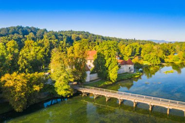 Slovenya 'daki Krka Nehri üzerindeki Otocec Kalesi' nin insansız hava görüntüsü ve ahşap köprü