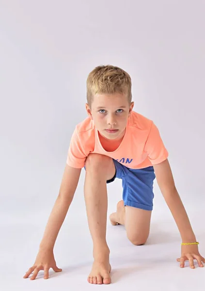boy sits at the start on a white background and looks ahead