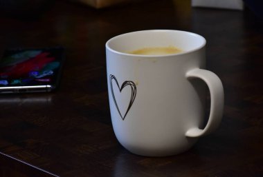 cup with coffee and smartphone on wooden table