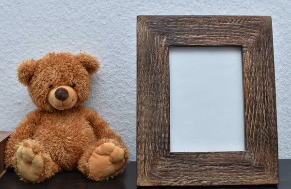 soft toy bear and wooden photo frame