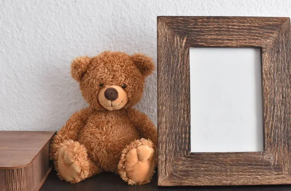 soft toy bear and wooden photo frame