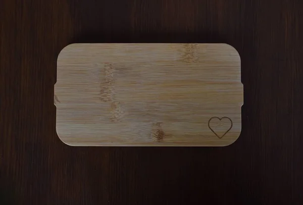 Hölzerne Leuchtplatte Mit Einem Verbrannten Herzen Auf Einem Braunen Tisch — Stockfoto