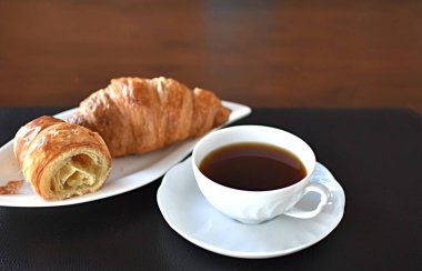 Kruvasan ve porselen bardakta çay.