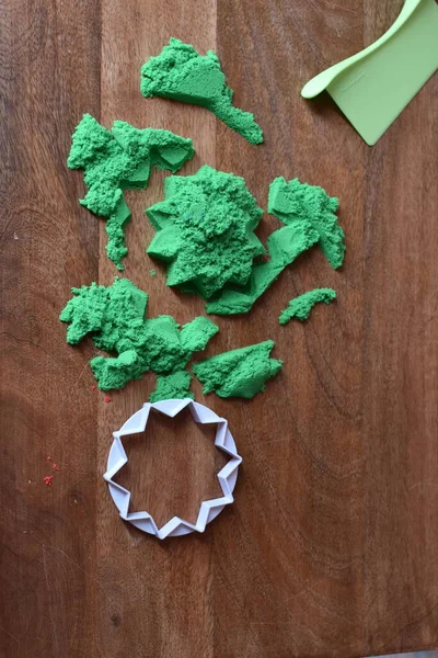 colored kinetic sand with a plastic mold for figures and a knife
