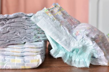 a pile of baby diapers on a wooden table clipart