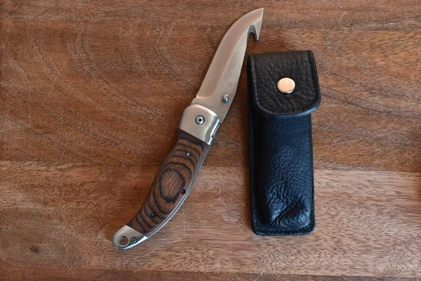 アヒル付きの観光ナイフと革の黒い鞘の横にある木製のハンドル — ストック写真