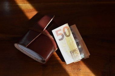 Tahta arka planda 50 Euro ve deri kaplı defter