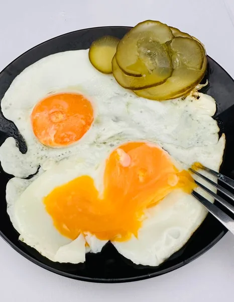 用叉子在黑盘上煎鸡蛋和泡菜 — 图库照片