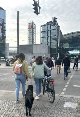 Berlin Almanya Mayıs 2023, ana istasyon ve yoldan geçenler bir köpek ve bisikletle köprü boyunca yürüyorlar.