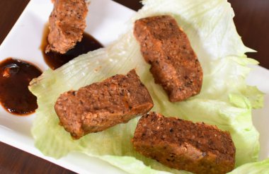 Vejetaryen bulgur topları, nar şurubu ve beyaz tabakta marul.