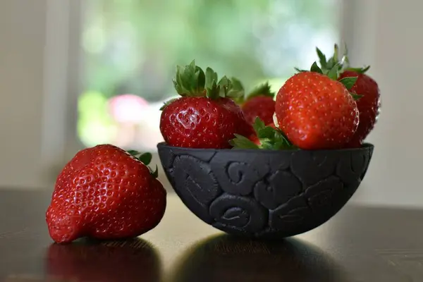 Reife Erdbeeren Einer Schwarzen Schüssel Vor Dem Fenster — Stockfoto