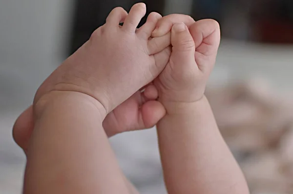 Enfant Tenant Les Jambes Avec Les Mains — Photo