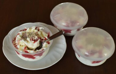 Çilek şuruplu dondurma. Beyaz bir çay tabağında plastik bir paket.