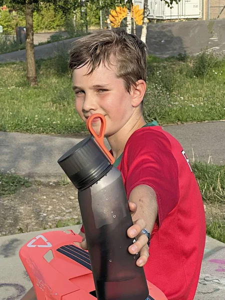 Chłopiec Czerwonej Koszulce Poci Się Sporcie Trzymając Butelkę Wody — Zdjęcie stockowe