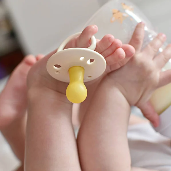 Child Drinks Milk Bottle His Legs Holds Pacifier His Toe — Stock Photo, Image