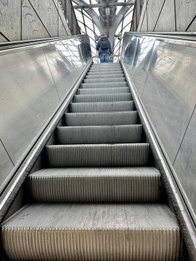 Son basamaktaki adam yürüyen merdivenin tepesinde.