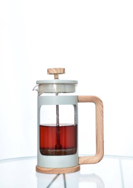 Cam bir masanın üzerinde çay yaprakları olan cam çaydanlık bardağı.