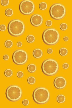 Sarı zemin üzerinde taze portakal dilimleri