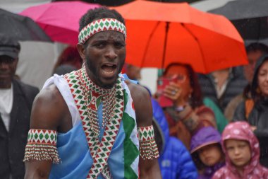 Winterthur İsviçre 06.07. 2025, Afrikalılar geleneksel kıyafetlerle çıplak ayakla dans ediyor Kışın yağmurda İsviçre 'de