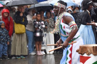 Winterthur İsviçre 06.07. 2025, Afrikalılar geleneksel kıyafetlerle çıplak ayakla dans ediyor Kışın yağmurda İsviçre 'de