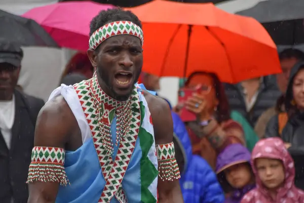 Winterthur İsviçre 06.07. 2025, Afrikalılar geleneksel kıyafetlerle çıplak ayakla dans ediyor Kışın yağmurda İsviçre 'de