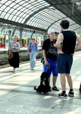 Berlin Germany 06.19.2025, young people and a girl are standing on the platform with a black dog on a leash