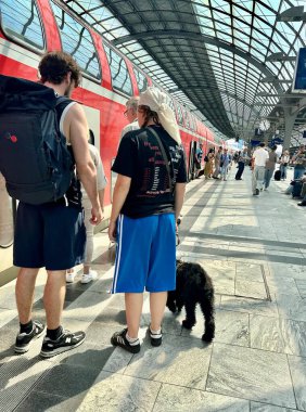 Berlin Germany 06.19.2025, young people and a girl are standing on the platform with a black dog on a leash