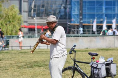 Berlin Germany  06.17.2025,Street musician playing saxophone near Berlin Central Station (Hauptbahnhof)Kategorie 1