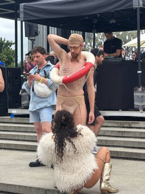 Berlin, Almanya, 28 Temmuz 2025. Berlin 'deki Kristof Caddesi (CSD) geçit töreninde katılımcılar bir kişinin kostümünün ayarlanmasına yardım ediyor.