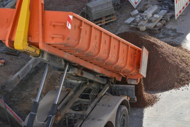 İnşaat alanına çöp kamyonu toprak boşaltıyor.