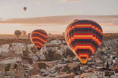 Hot air balloons flying low over hotels in Goreme in Cappadocia, Turkey