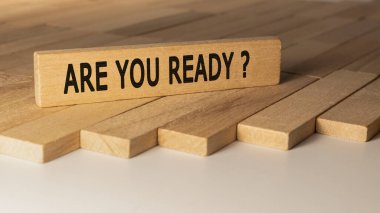 Are you ready text. It is written on a wooden surface. The background is white..