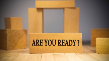 Are you ready text. It is written on a wooden surface. The background is white..