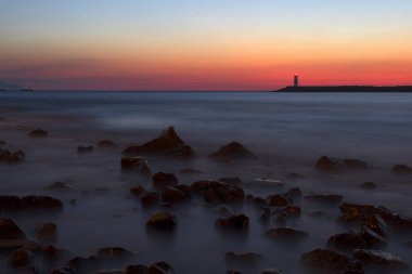 Gün batımı ve deniz manzarası. Fotoğraf, uzun pozlama tekniğiyle çekildi. Türkiye Kusadas Sahili.  
