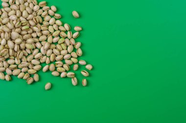 pistachos esparcidos on la esquina superior sobre fondo verde
