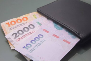 Arjantin parası - Arjantin parası, Pesos Argentinos, karanlık arka planda bir cüzdanın içinde on bin peso nakit para. Nakit para
