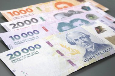 Arjantin parası, Arjantin para birimi, Pesos Argentinos. Birkaç Arjantin pezosu yığını, karanlık arka planda bin peso nakit para, 20 bin peso nakit para.