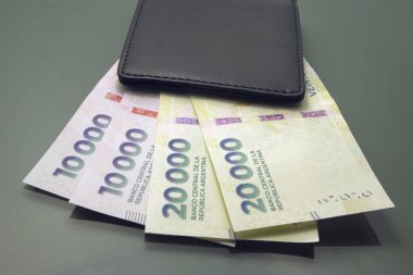 Arjantin parası, Arjantin parası, Pesos Argentinos, bir cüzdanın içindeki çeşitli banknotlar, yakın plan karanlık arka plan. 20 bin peso nakit.