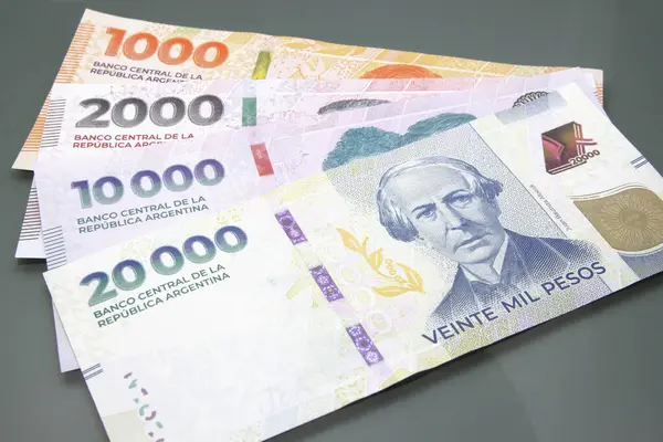 Arjantin parası, Arjantin para birimi, Pesos Argentinos. Birkaç Arjantin pezosu yığını, karanlık arka planda bin peso nakit para, 20 bin peso nakit para.