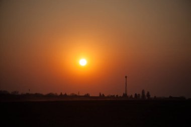 Sahada gün batımı. Doğada güzel bir gün batımı. Kırsal doğa gün batımında. Kızıl gün batımı manzarası