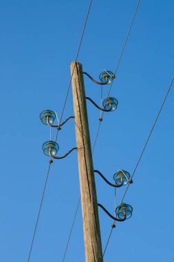 Ahşap bir elektrik direği, mavi bir arka planda, arka planda ay var..