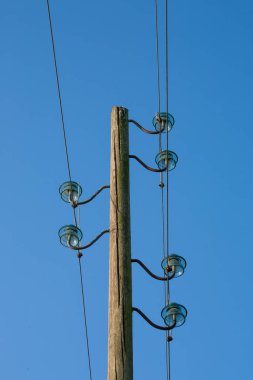 Ahşap bir elektrik direği, mavi bir arka planda, arka planda ay var..