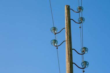 Ahşap bir elektrik direği, mavi bir arka planda, arka planda ay var..