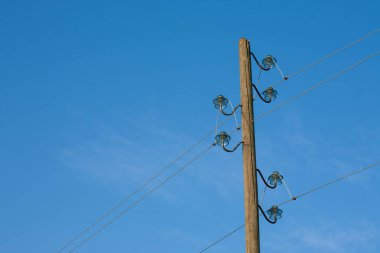 Ahşap bir elektrik direği, mavi bir arka planda, arka planda ay var..