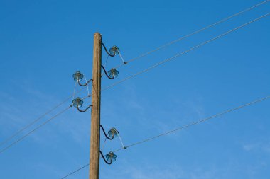 Ahşap bir elektrik direği, mavi bir arka planda, arka planda ay var..