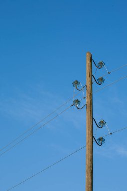 Ahşap bir elektrik direği, mavi bir arka planda, arka planda ay var..