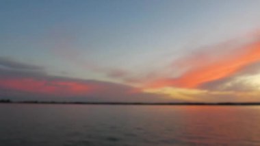 Gün batımında suyun üstünde inanılmaz renkli bir gökyüzü. Gün batımında tatlı sarı gökyüzü ve panoramik manzarası olan güzel bir manzara. Dramatik Gökyüzü tatlı günbatımında ve sarı renkte