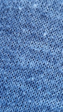 Ayrıntılı dikişleri, dokuyu ve deseni gösteren mavi örgü kumaşın yakın görüntüsü, tekstil ve tasarım kavramları için mükemmeldir.